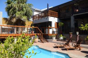 a patio with two chairs and a swimming pool at New Stone Manor in Mossel Bay