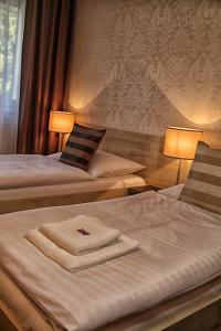 a hotel room with two beds with towels on them at Hotel U Kašny in Rajhrad