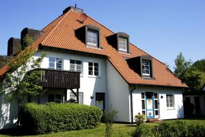 une maison blanche avec un toit orange dans l'établissement Feriendomizil Prerow, à Prerow