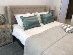 duże łóżko z 2 zielonymi poduszkami w obiekcie Luxury apartment in La Isla, Puerto Banus w Marbelli
