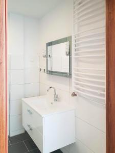 a white bathroom with a sink and a mirror at Hotel Denbu Restaurant & BAR in Hamburg