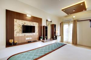 a living room with a flat screen tv on a wall at White Castle Boutique Apartment Hotel in Bangalore