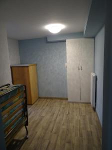 Apartment Staudacker في Drage: غرفه فارغه مع غرفه ارضيه خشبيه وثلاجه