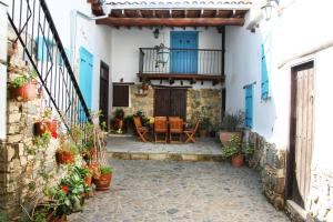 a courtyard of a house with a table and a balcony at Aperanti Agrotourism in Pera Orinis