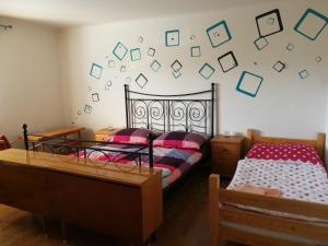 a bedroom with two beds and a wall with pictures on it at Apartment Pražská in Rokycany