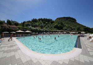 - un groupe de personnes se baignant dans une piscine dans l'établissement Hotel La Perla - Bike Hotel, à Garde