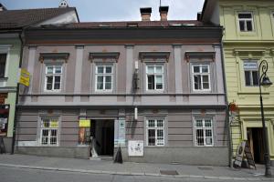 een roze gebouw aan de kant van een straat bij GRAN hostel in Banská Bystrica