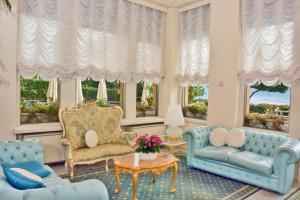 a living room with blue furniture and windows at Grand Hotel Menaggio in Menaggio