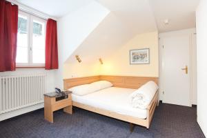 Ένα ή περισσότερα κρεβάτια σε δωμάτιο στο Hotel Jungfrau Mürren
