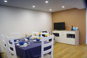 a dining room with a table and a television at A Nossa Praia in Praia da Barra