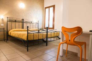 a bedroom with a bed with a desk and a chair at Domus Clugiae in Chioggia