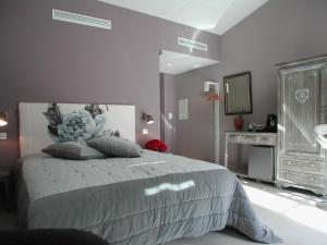 una camera da letto con un letto con specchio e un comò di L' Oustau Blanc B&B a Fontvieille