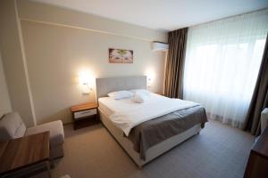 Un pat sau paturi într-o cameră la Bruxelles Guesthouse Craiova