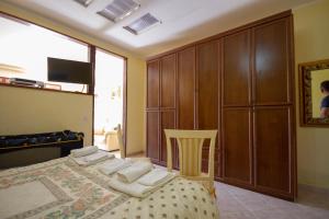 - une chambre avec un lit et une armoire en bois dans l'établissement Hotel Dory, à Albinia