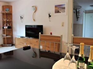 a living room with a table with two wine bottles at Beautiful Apartment in Damshagen near the Sea in Damshagen