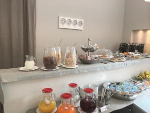 um balcão com muitos tipos diferentes de alimentos em frascos de vidro em MA Hotel em Santa Margherita Ligure