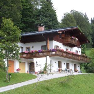 uma grande casa branca com uma varanda em Gästehaus ERLE em Ramsau am Dachstein