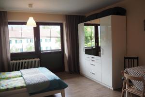 a bedroom with a bed and a white cabinet with a dresser at Studio App. 337 mit Blick auf die Berge in Inzell