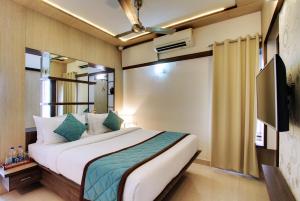 a bedroom with a large bed and a television at White Castle Boutique Apartment Hotel in Bangalore +32 photos