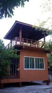 a house with a balcony on top of it at JJ Beach Resort & JJ Seafood in Ko Phayam