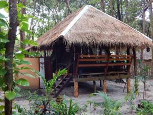 a hut with two chairs and a thatched roof at JJ Beach Resort & JJ Seafood in Ko Phayam