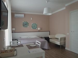 a white bedroom with a bed and a chair at Palazzo Ducale in San Severo