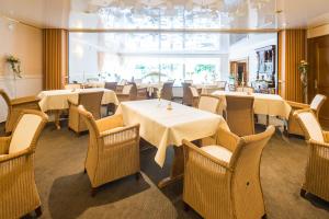 a restaurant with tables and chairs and a large window at Moselromantik-Hotel zum Löwen in Ediger-Eller