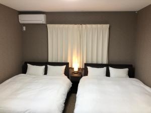 2 Betten nebeneinander in einem Zimmer in der Unterkunft Kyogura Bettei Nijo in Kyoto
