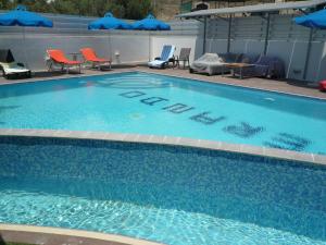 a large blue swimming pool with chairs and umbrellas at Esperando in Maroni