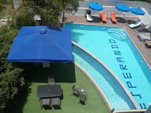 an overhead view of a swimming pool with a blue umbrella at Esperando in Maroni