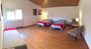 ein Zimmer mit drei Betten und einem Tisch und Stühlen in der Unterkunft Villa Bella Portbou in Portbou + 37 Fotos