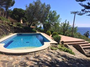 ein Pool mit Treppe und das Meer im Hintergrund in der Unterkunft Villa Bella Portbou in Portbou