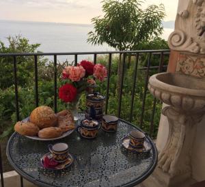 a table with a plate of food on a balcony at Casa Rosetta in Praiano