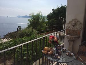 a table with a bowl of bread and flowers on a balcony at Casa Rosetta in Praiano