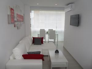 マルベーリャにあるApartamento Fontanillaのリビングルーム(白いソファ、テーブル付)