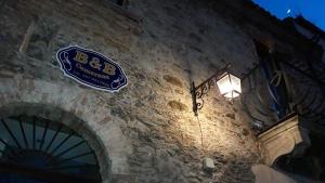 a sign on the side of a stone building at PALAZZO CAMERANa in Messina