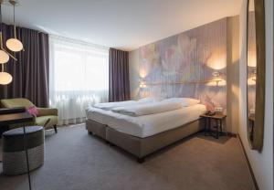a bedroom with a bed with a painting on the wall at Parkhotel Schmid in Adelsried +43 photos