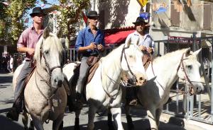 three men are riding on white horses down the street at L' Oustau Blanc in Fontvieille +13 photos