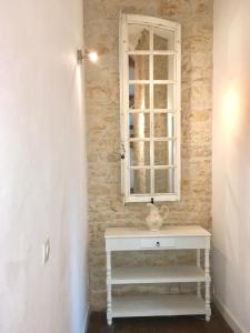a bathroom with a white sink and a window at Le Logis de Limalonges in Limalonges