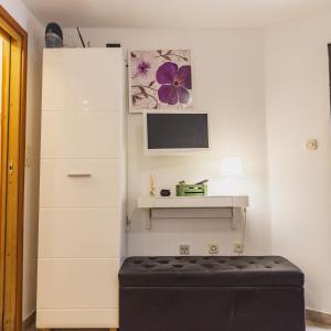 a room with a tv and a black ottoman at Studio Old Town in Split