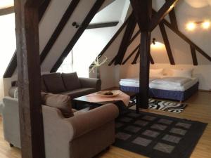 a living room with a couch and a bed at Parkhotel Helmstedt in Helmstedt