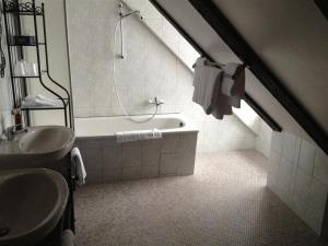 a bathroom with a sink and a bath tub at Parkhotel Helmstedt in Helmstedt +9 photos