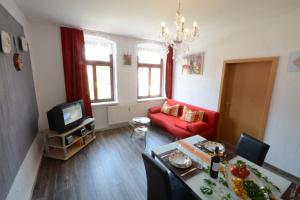 a living room with a red couch and a tv at Elbidylle in Königstein an der Elbe