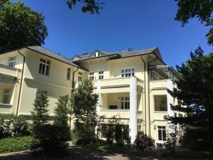 a large white building with trees in front of it at Villa Caprivi 1 in Heringsdorf +12 photos