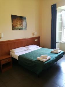 a bedroom with a bed with two towels on it at In Rome in Rome