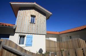 a white house with a wooden fence at Residence Plage Oceane in Biscarrosse-Plage