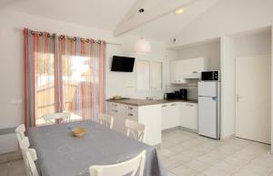 a kitchen with a table and chairs and a kitchen with a refrigerator at Residence Plage Oceane in Biscarrosse-Plage