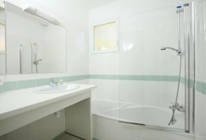 a white bathroom with a sink and a shower at Residence Plage Oceane in Biscarrosse-Plage