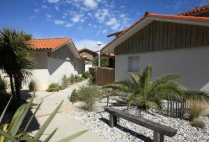 a wooden bench in front of a house at Residence Plage Oceane in Biscarrosse-Plage