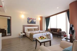 a bedroom with a bed and a living room at Forum Suite Otel in Mersin